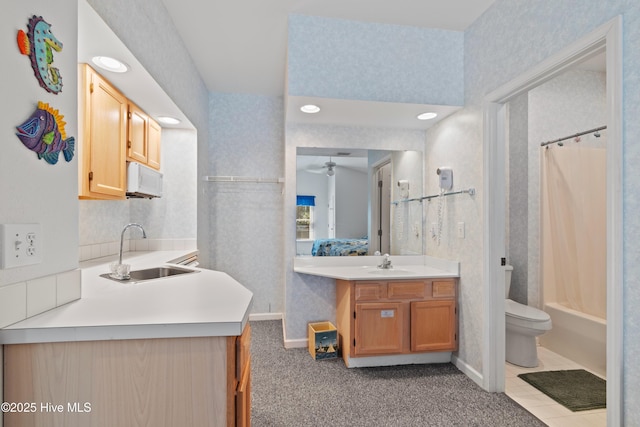 ensuite bathroom featuring vanity, toilet, and wallpapered walls