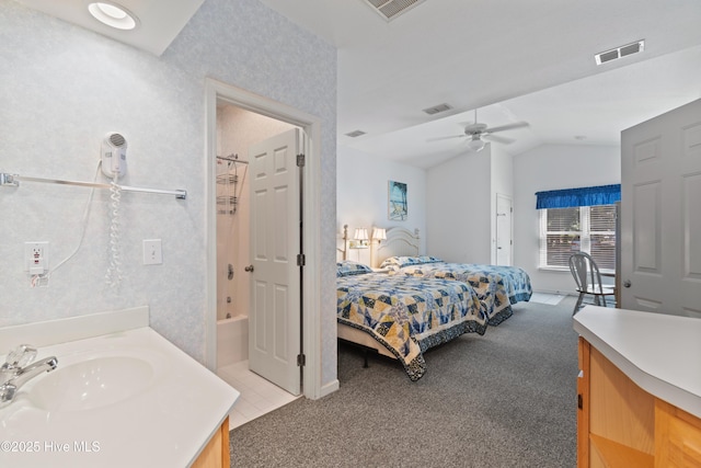 bedroom with vaulted ceiling, a sink, visible vents, and light colored carpet