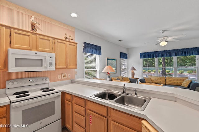 kitchen with open floor plan, light countertops, white appliances, and a sink