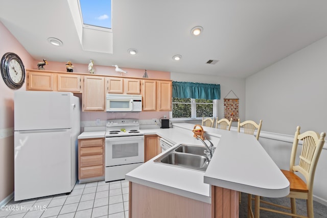 kitchen featuring white appliances, visible vents, a sink, and light brown cabinetry