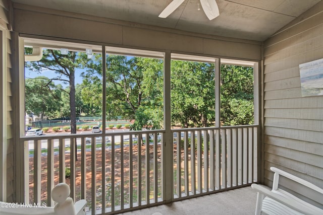 unfurnished sunroom featuring ceiling fan and plenty of natural light