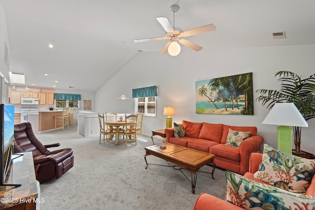 living area featuring lofted ceiling, ceiling fan, visible vents, and light colored carpet