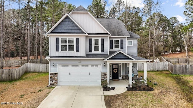 craftsman house featuring driveway, a front lawn, fence, board and batten siding, and a garage