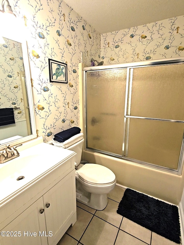 bathroom with vanity, wallpapered walls, tile patterned flooring, a textured ceiling, and toilet