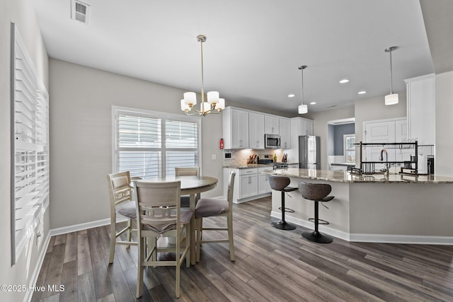 dining space with visible vents, dark wood-type flooring, recessed lighting, baseboards, and a chandelier