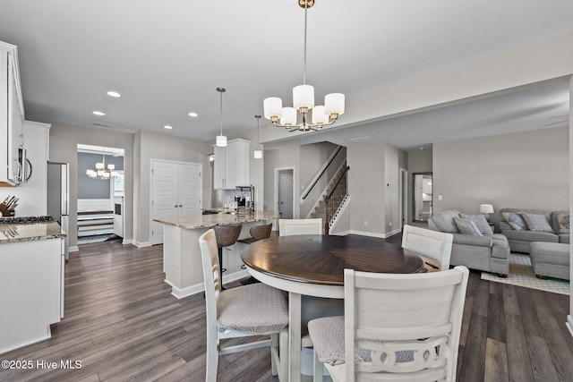 dining space with recessed lighting, stairway, a notable chandelier, and dark wood-style floors