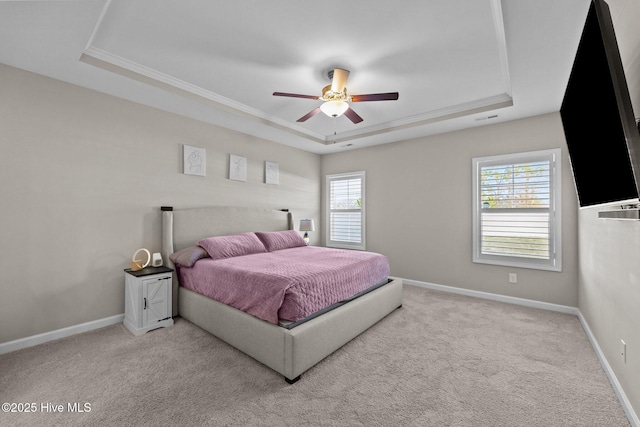 bedroom featuring a raised ceiling, multiple windows, carpet, and baseboards