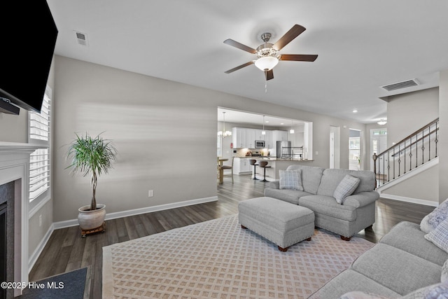 living area with wood finished floors, baseboards, a ceiling fan, visible vents, and a premium fireplace