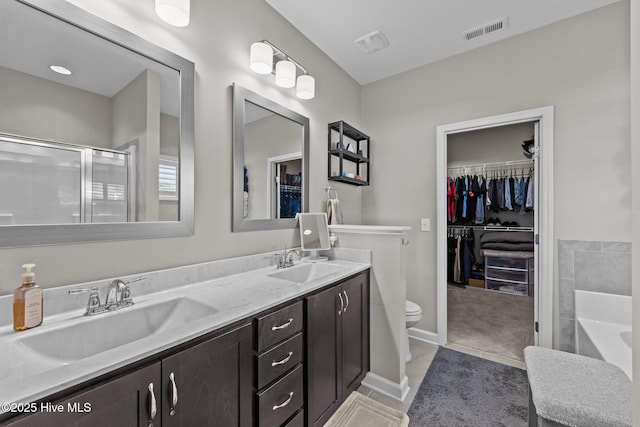 full bath with a sink, visible vents, double vanity, and a tub