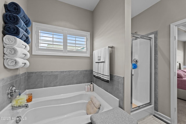 bathroom featuring a garden tub and a shower stall