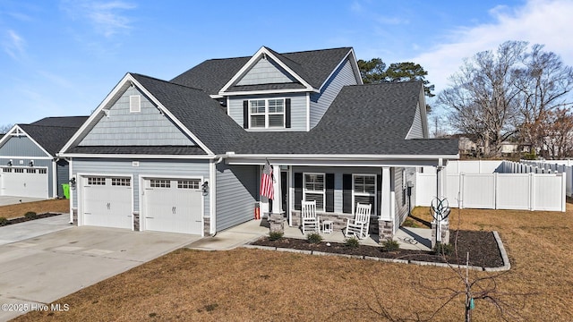 view of front of house featuring driveway, a porch, fence, an attached garage, and a front yard