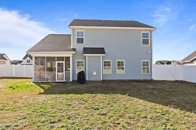 rear view of property with a shingled roof, a lawn, a fenced backyard, and a sunroom