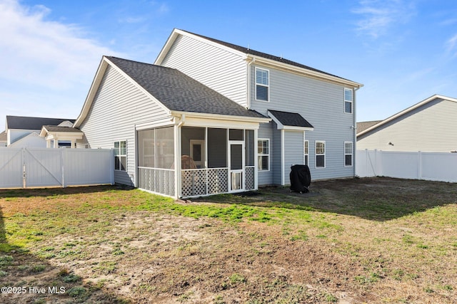 rear view of property featuring a lawn, roof with shingles, a fenced backyard, and a sunroom