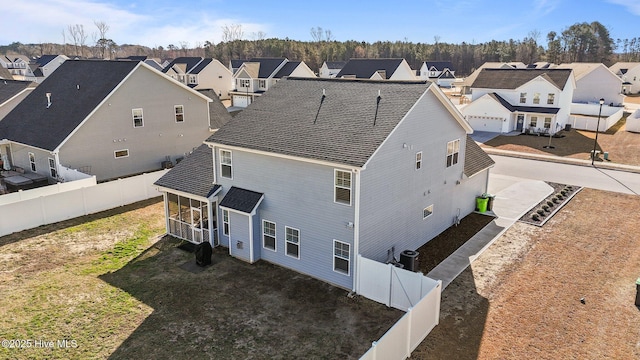 rear view of property with a residential view, a fenced backyard, and a shingled roof