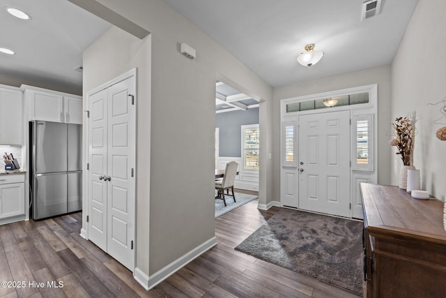 entryway featuring dark wood-style floors, visible vents, coffered ceiling, baseboards, and beamed ceiling