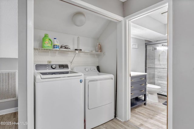 laundry area featuring light wood-style floors, laundry area, and separate washer and dryer