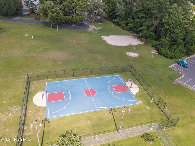 view of basketball court featuring community basketball court, fence, and a lawn