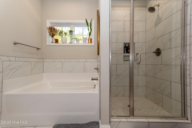 full bathroom featuring a garden tub and a shower stall