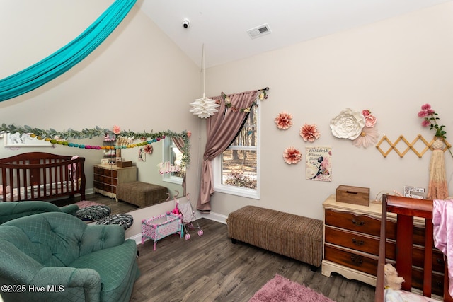 bedroom featuring baseboards, visible vents, vaulted ceiling, and wood finished floors