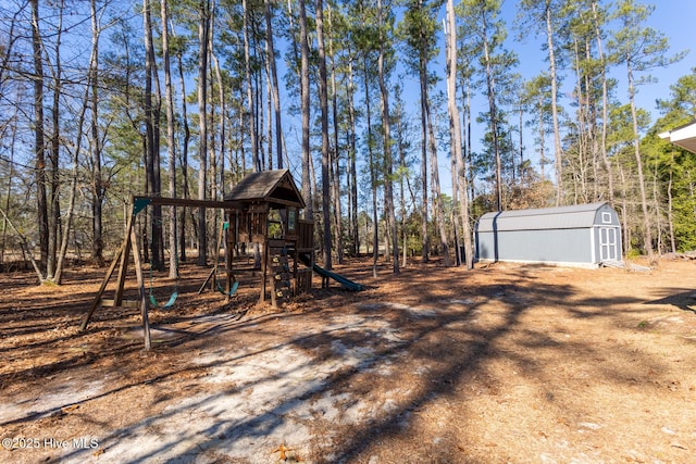 view of yard featuring an outbuilding, a playground, and a storage unit