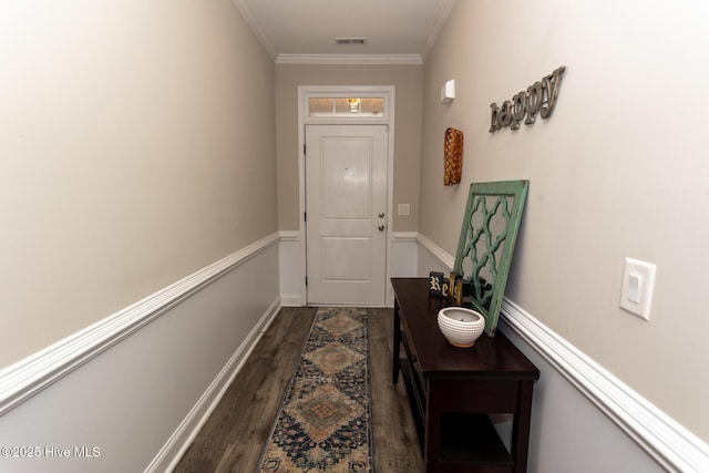 doorway featuring dark wood-style floors, ornamental molding, visible vents, and baseboards