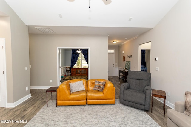 living room with visible vents, baseboards, and wood finished floors