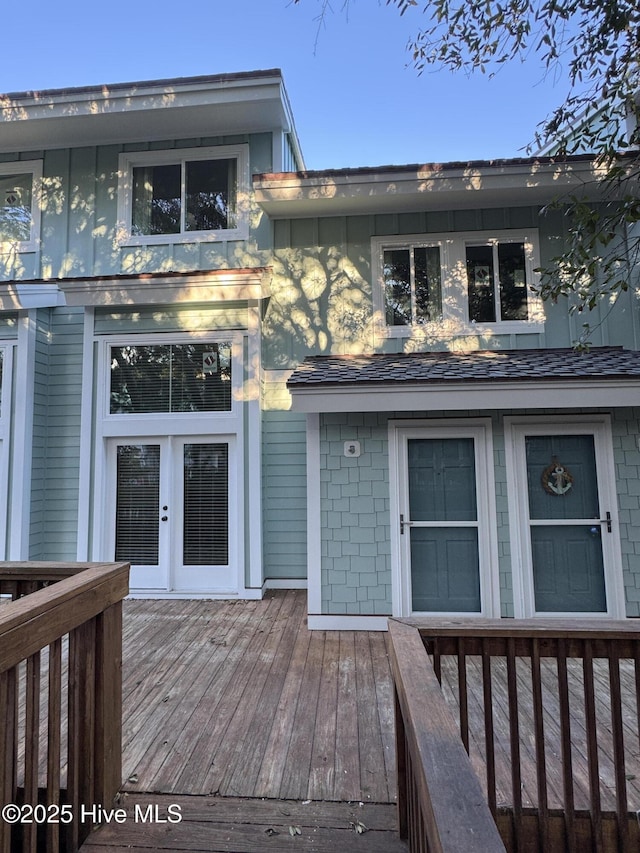 exterior space with roof with shingles and a wooden deck