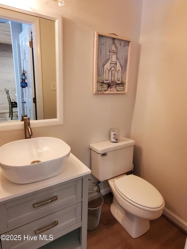 bathroom with vanity, wood finished floors, toilet, and baseboards