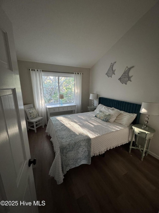 bedroom featuring lofted ceiling and wood finished floors