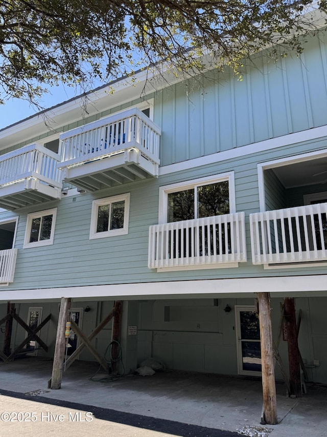 view of home's exterior with board and batten siding and a carport