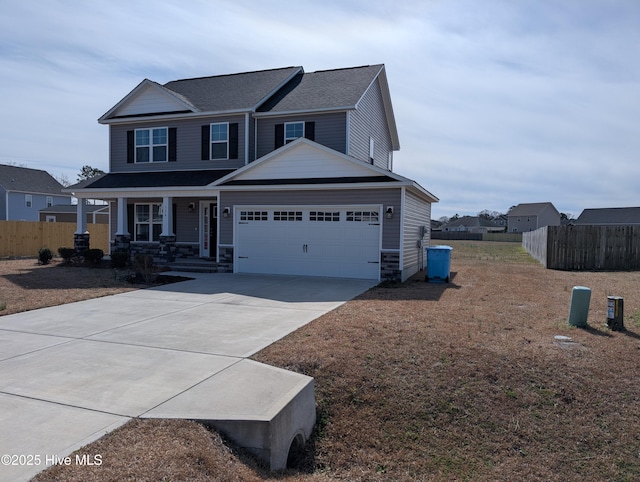 view of front of home with covered porch, concrete driveway, fence, and a garage