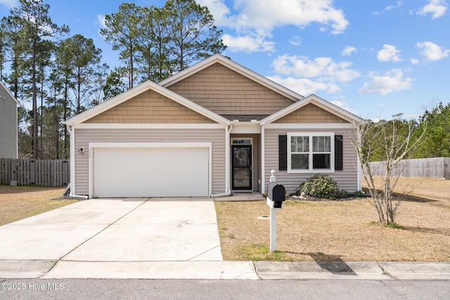 view of front facade with a garage, driveway, and fence