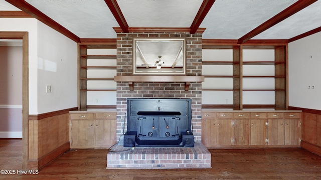 unfurnished living room with dark wood-style floors, built in features, wainscoting, wooden walls, and a textured ceiling