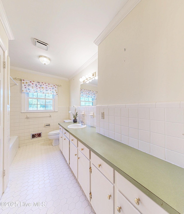 full bath with tile patterned flooring, toilet, visible vents, tile walls, and crown molding