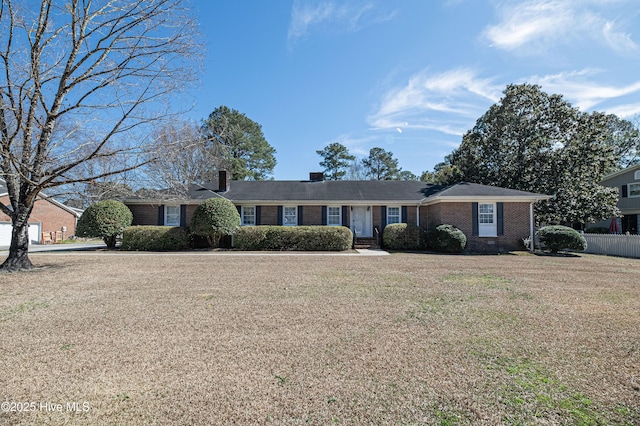 single story home with a front yard, brick siding, and fence