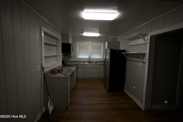 kitchen with stainless steel appliances, dark wood finished floors, open shelves, and a sink