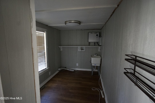 clothes washing area featuring laundry area, baseboards, dark wood-style flooring, hookup for a washing machine, and a sink