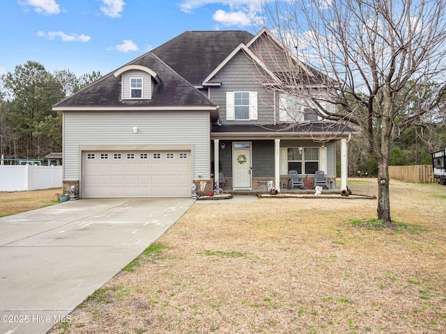 view of front of home with fence, a porch, a front yard, driveway, and an attached garage