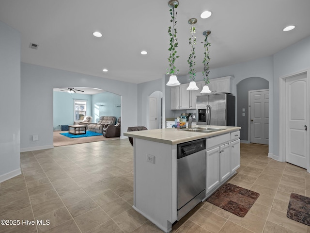 kitchen featuring visible vents, arched walkways, a sink, stainless steel appliances, and white cabinetry