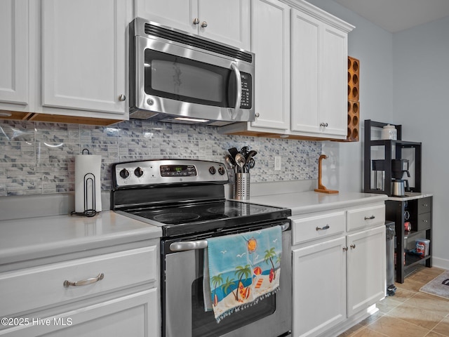 kitchen featuring tasteful backsplash, white cabinetry, appliances with stainless steel finishes, light countertops, and light tile patterned floors