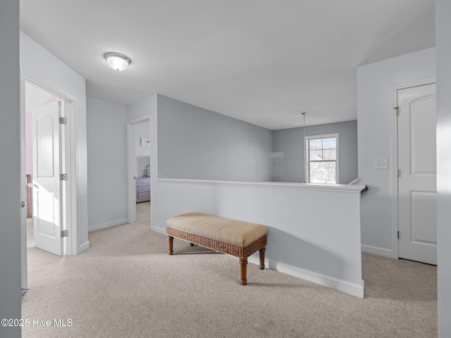 corridor featuring baseboards, an upstairs landing, and carpet flooring