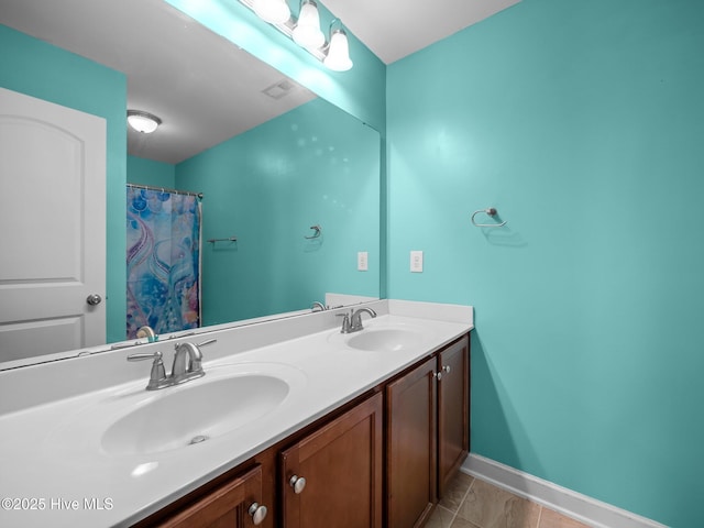 full bath with double vanity, baseboards, and a sink