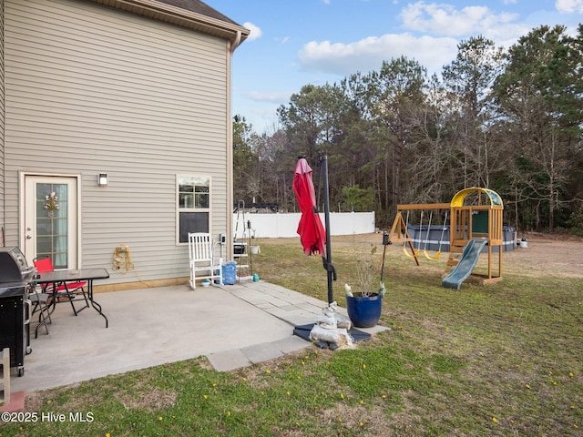 view of yard featuring a patio, fence, and a playground