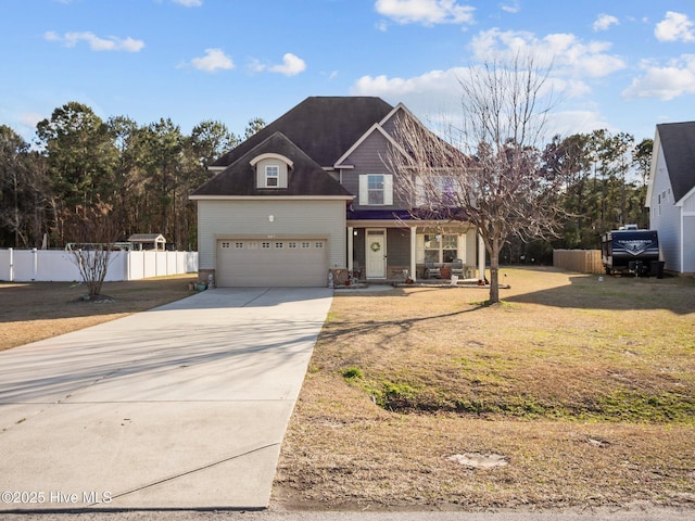 view of front of house featuring a front lawn, fence, covered porch, concrete driveway, and an attached garage