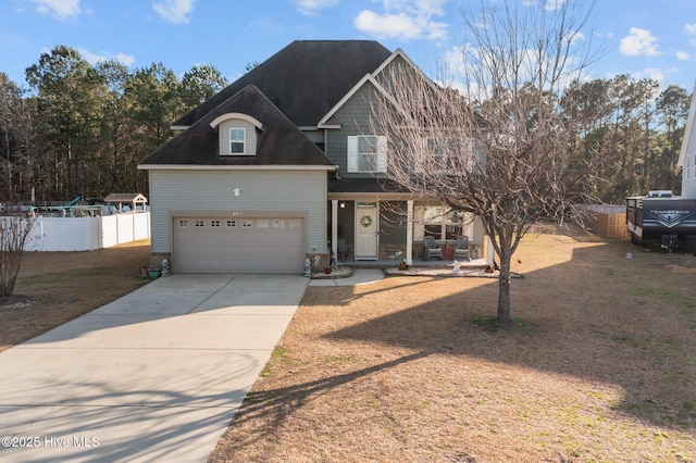 view of front of property featuring a garage, a porch, driveway, and fence