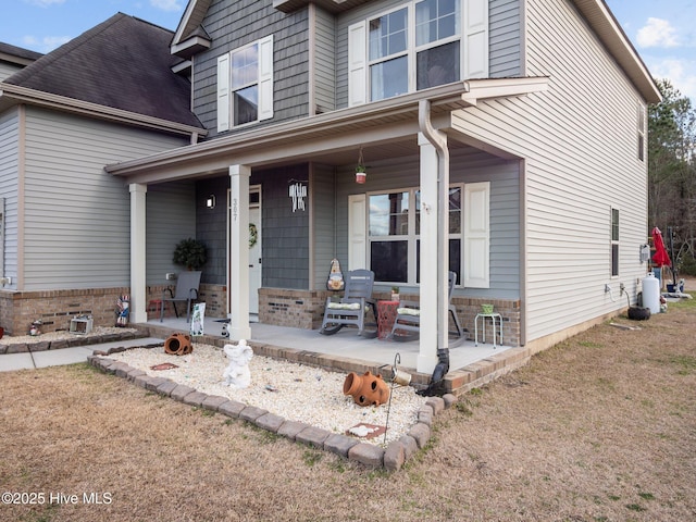 traditional-style house featuring a porch and brick siding