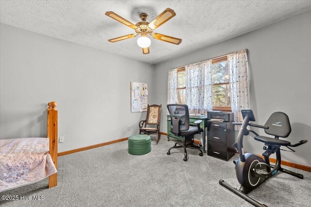 interior space featuring a textured ceiling, baseboards, a ceiling fan, and carpet floors