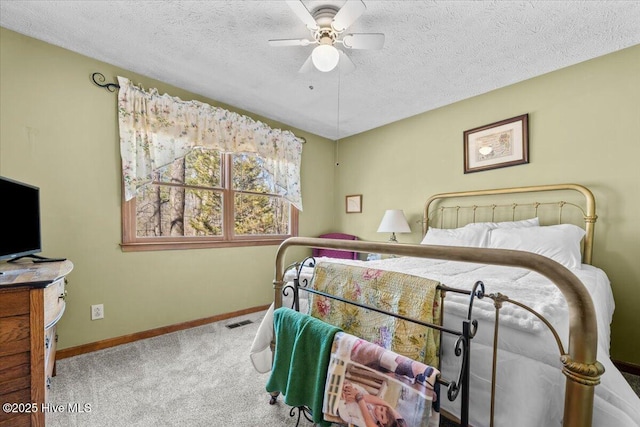 carpeted bedroom featuring a textured ceiling, ceiling fan, visible vents, and baseboards