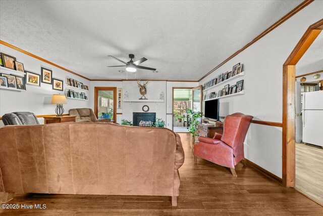 living area featuring crown molding, wood finished floors, and a healthy amount of sunlight