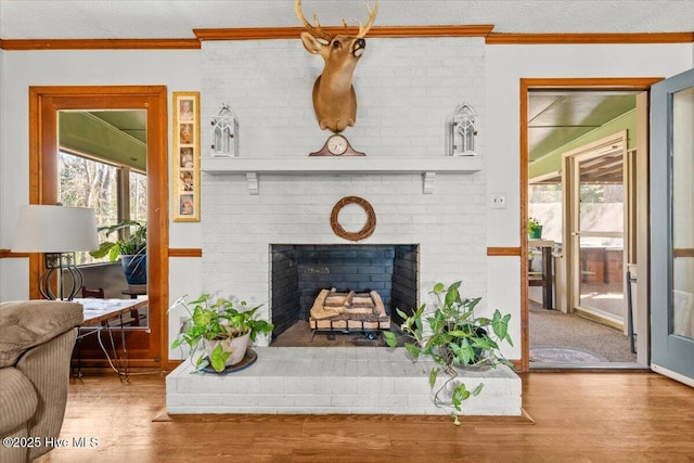 living area with a healthy amount of sunlight, a brick fireplace, and crown molding